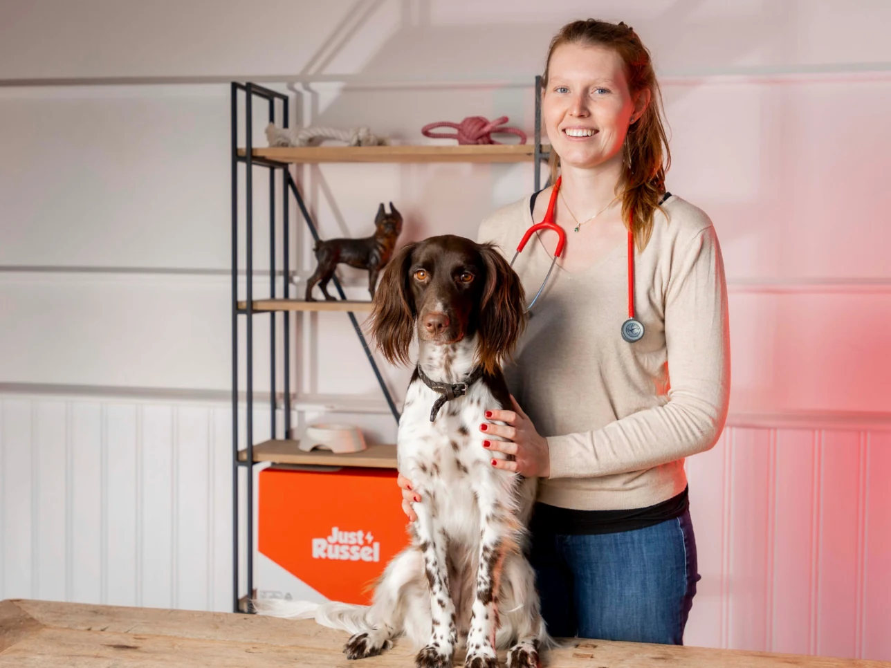 Tierärztin mit Hund im Just Russel Studio, bereit, individualisietes Futter zu empfehlen.
