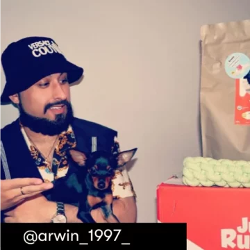 Zufriedener Kunde präsentiert mit seinem Hund seine Just Russel Lieferung.